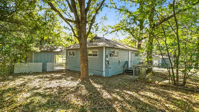a view of a house with a tree in the yard