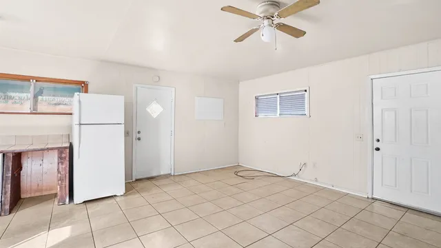 a view of a livingroom with a ceiling fan and refrigerator