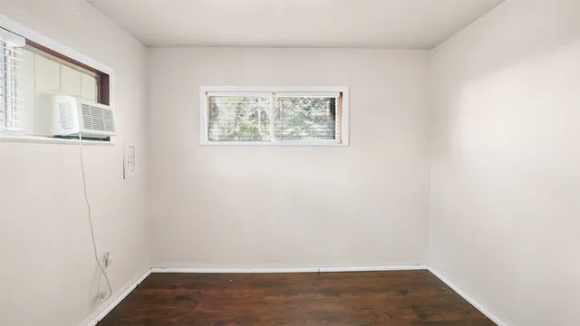 a view of a small space with wooden floor and a window
