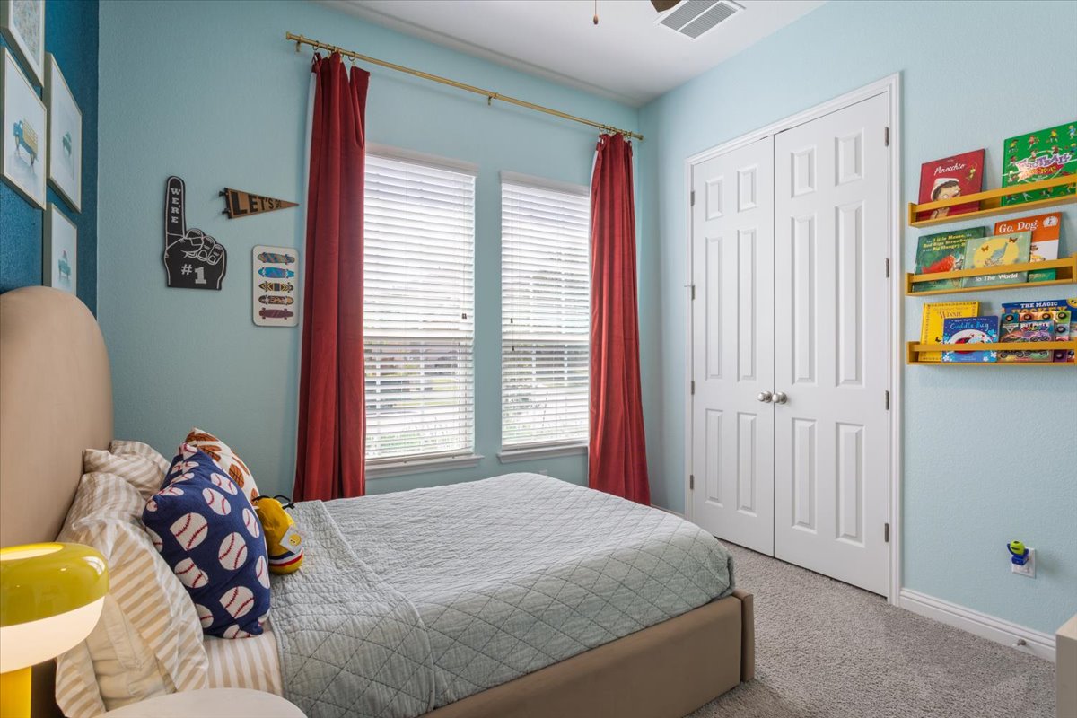 424 Millard Street Georgetown, TX 78628 - Photo 26 of 37 Two luminous windows frame the sleeping area in this inviting, comfortable bedroom.