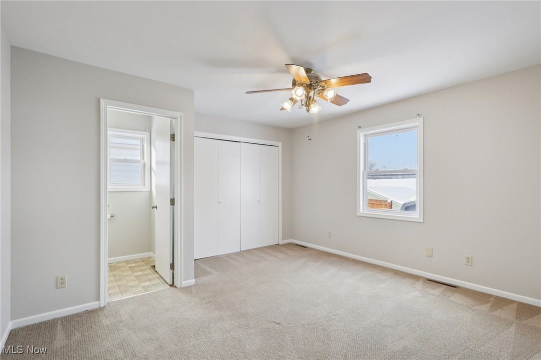611 Wilson Street Struthers, OH 44471 - Photo 17 of 44 Unfurnished bedroom with light carpet, a ceiling fan, and a closet
