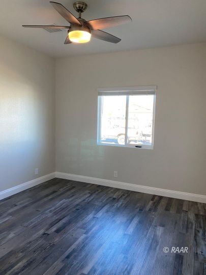 1034 Ocean Avenue Ridgecrest, CA 93555 - Photo 23 of 30 an empty room with wooden floor and windows
