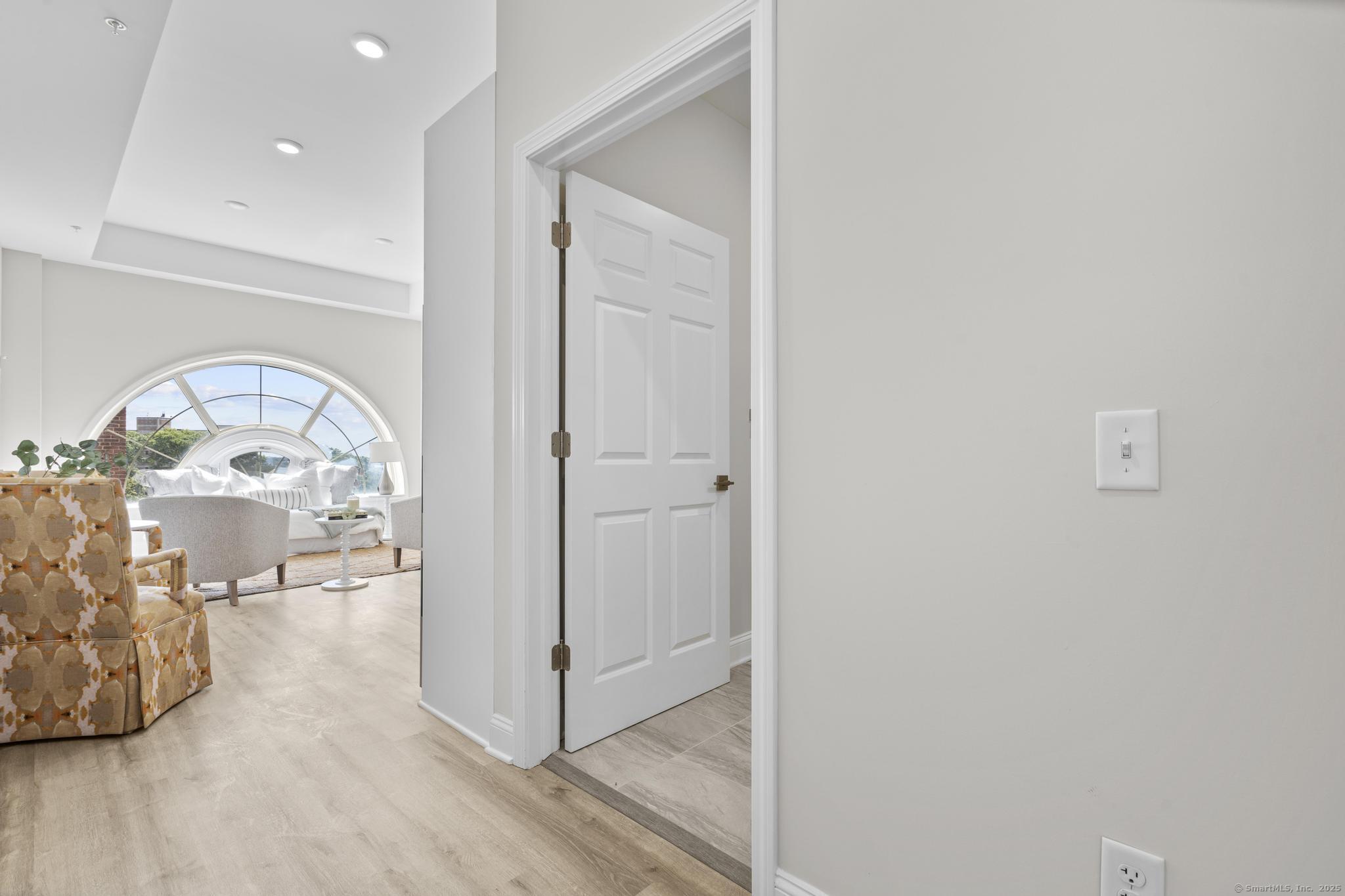 120 Broad Street, Unit 407 New London, CT 06320 - Photo 12 of 18 an empty room with mirror and a wooden floor