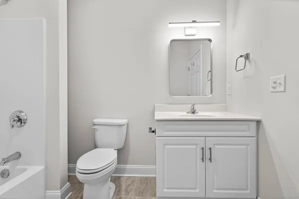 a bathroom with a toilet a sink and mirror