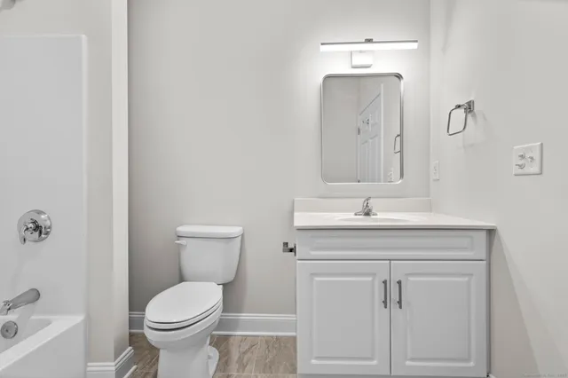 a bathroom with a toilet a sink and mirror