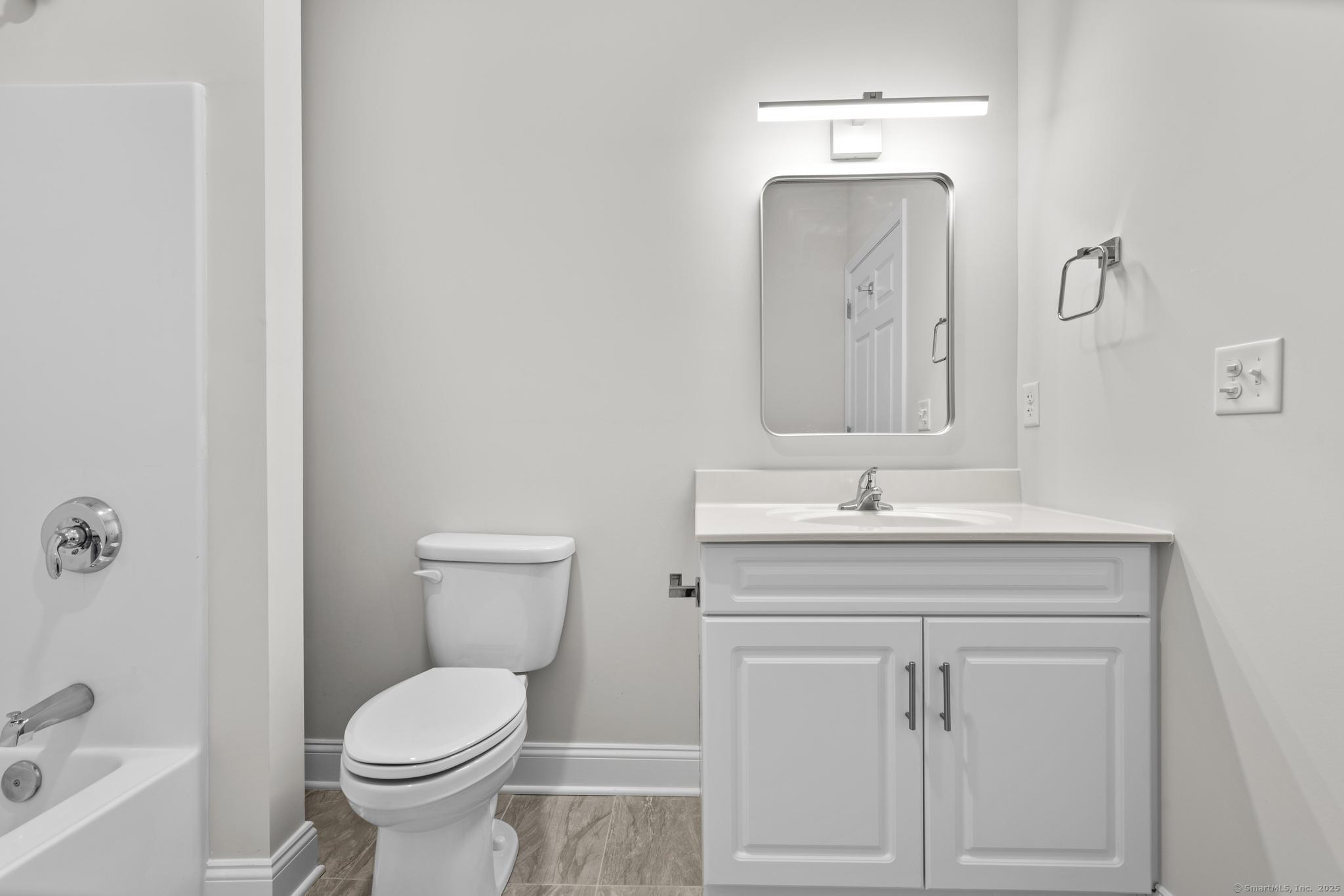 120 Broad Street, Unit 407 New London, CT 06320 - Photo 14 of 18 a bathroom with a toilet sink and mirror