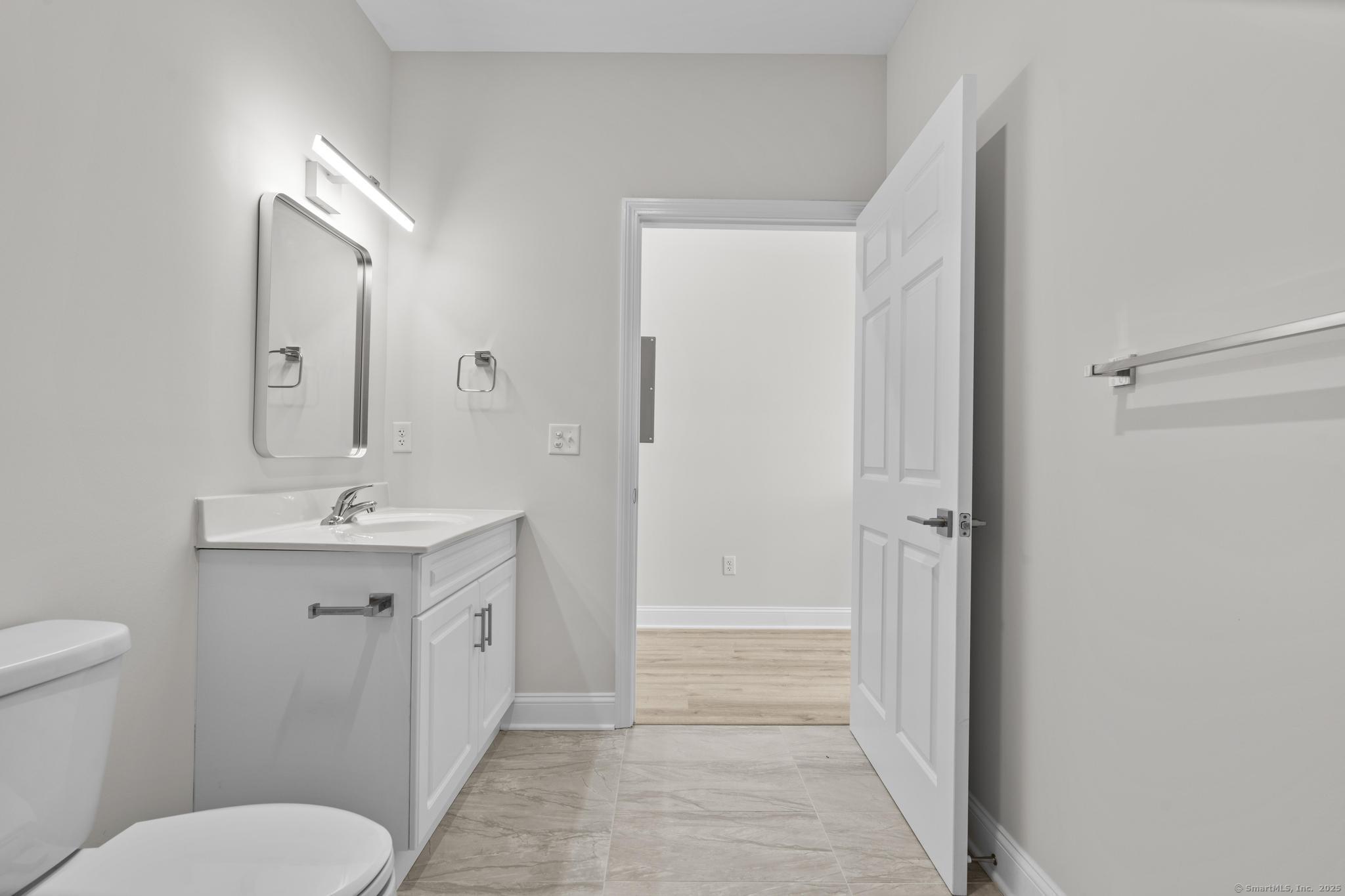 120 Broad Street, Unit 407 New London, CT 06320 - Photo 15 of 18 a bathroom with a toilet a sink and mirror