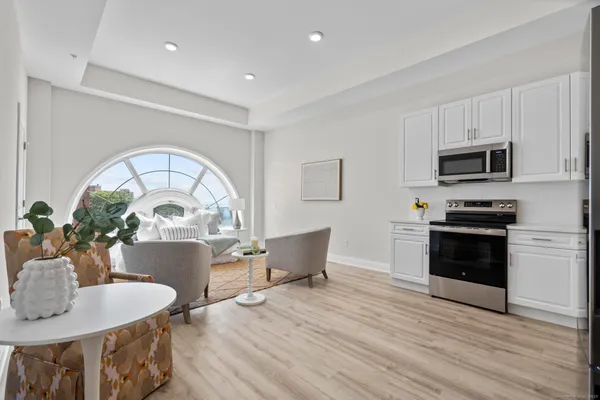 a kitchen with sink a microwave dining table and chairs