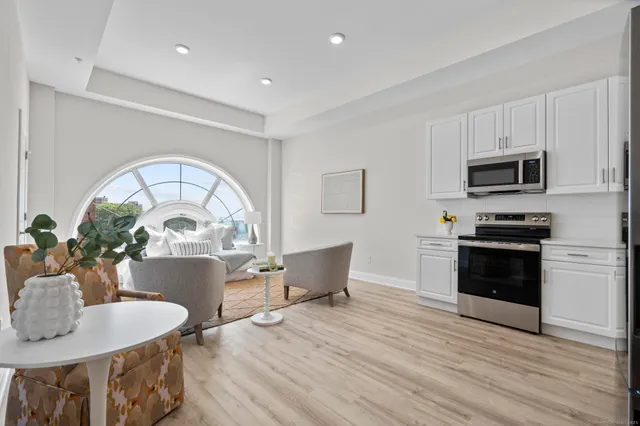 a kitchen with sink a microwave dining table and chairs