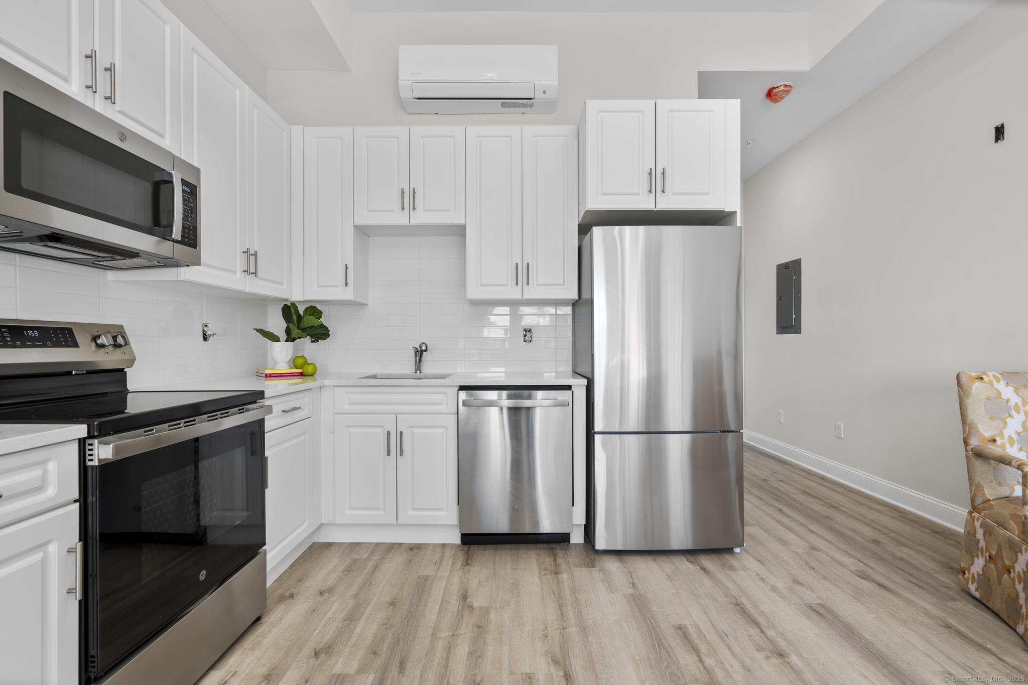 120 Broad Street, Unit 407 New London, CT 06320 - Photo 6 of 18 a kitchen with stainless steel appliances a refrigerator stove and microwave