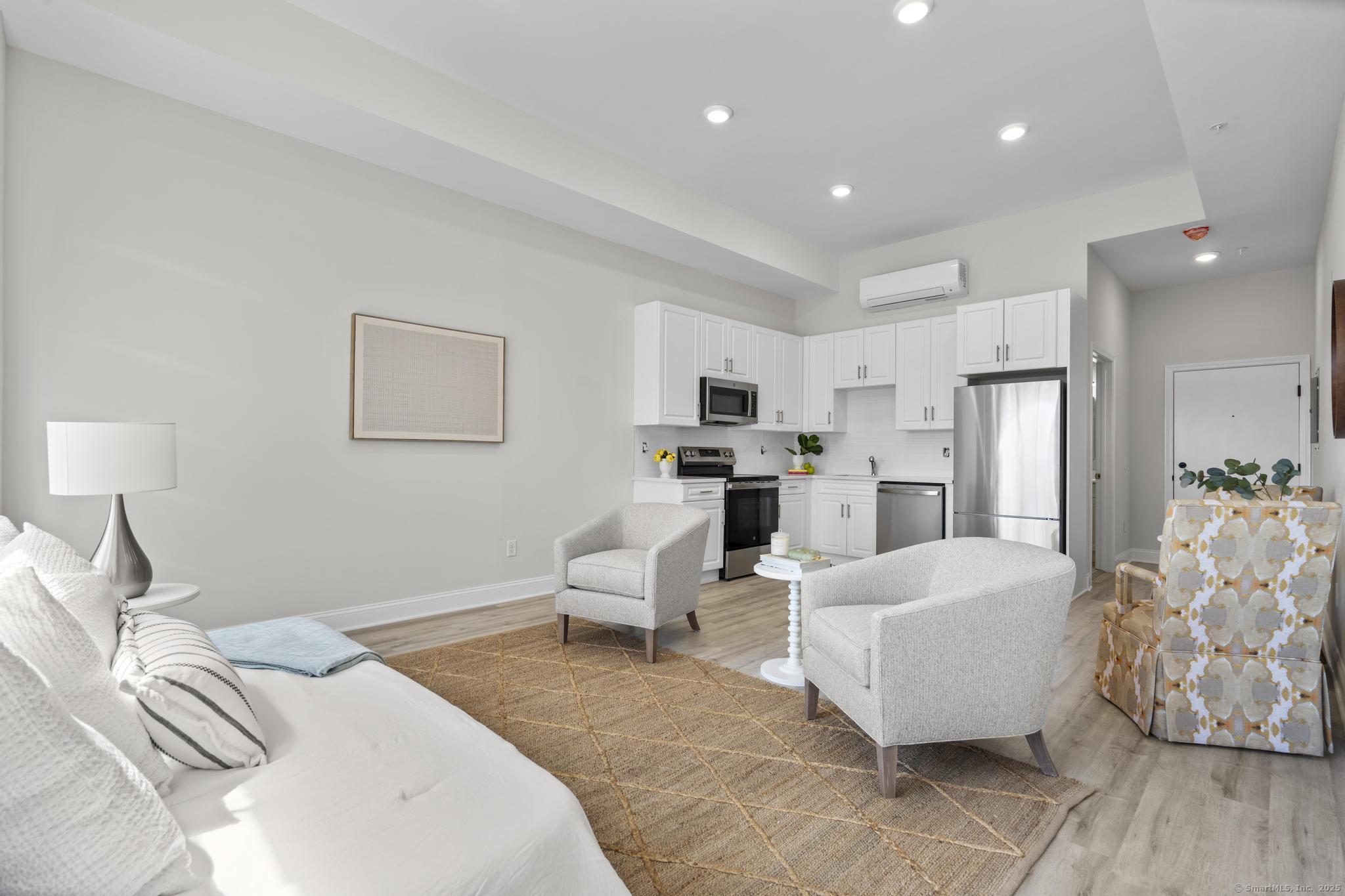 120 Broad Street, Unit 407 New London, CT 06320 - Photo 8 of 18 a bed room with furniture and a chandelier