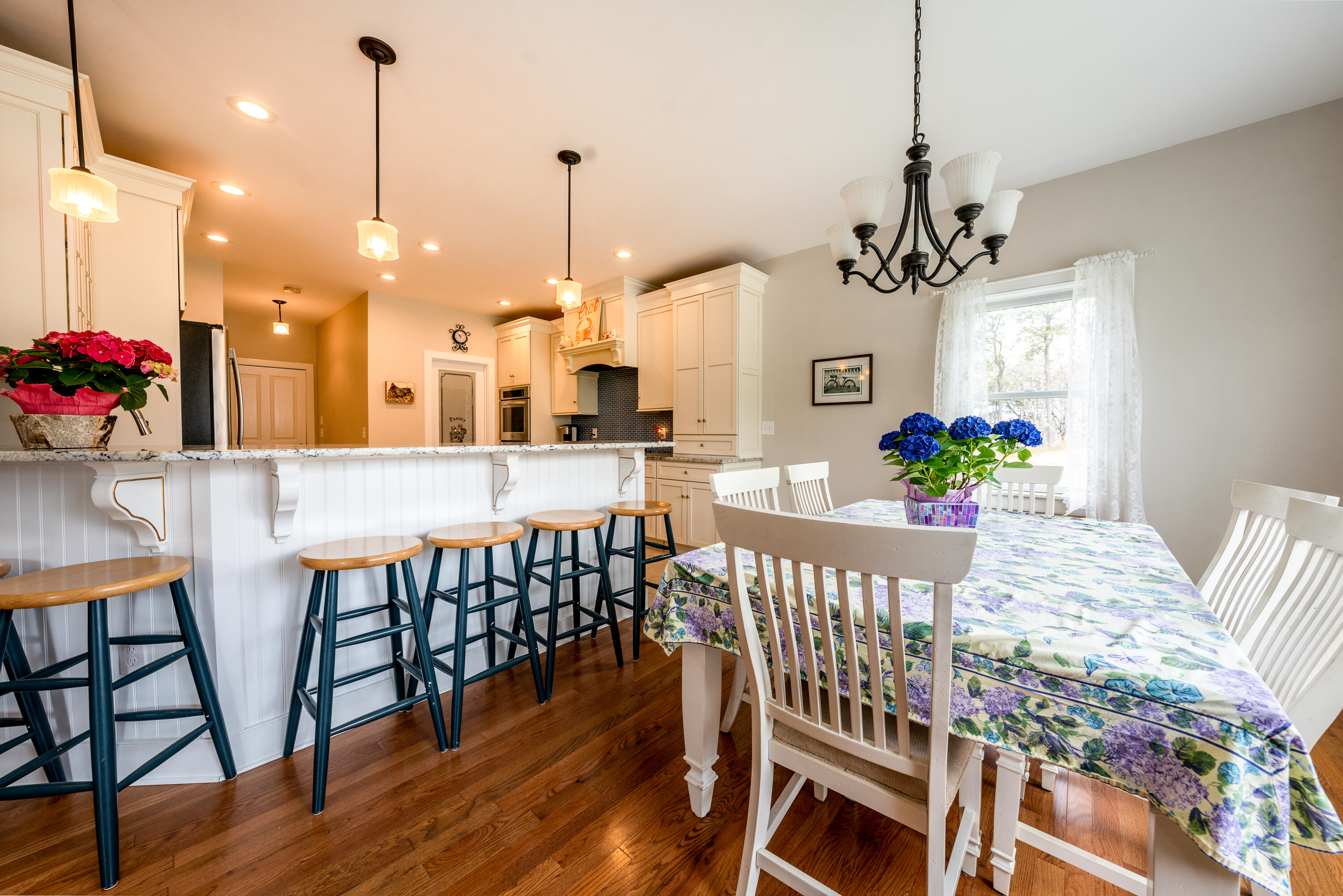 21 Jillian Drive Bourne, MA 02532 - Photo 13 of 46 a view of a dining room and livingroom with furniture wooden floor a chandelier