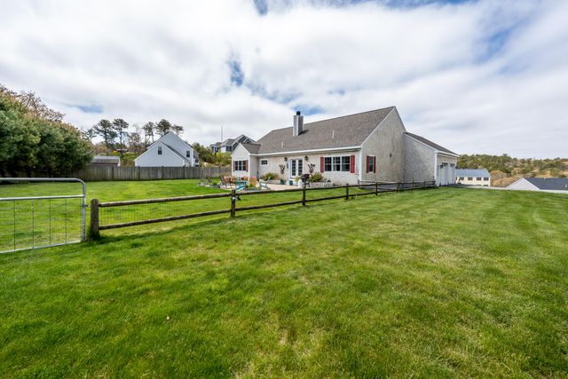a view of a house with a big yard and large trees