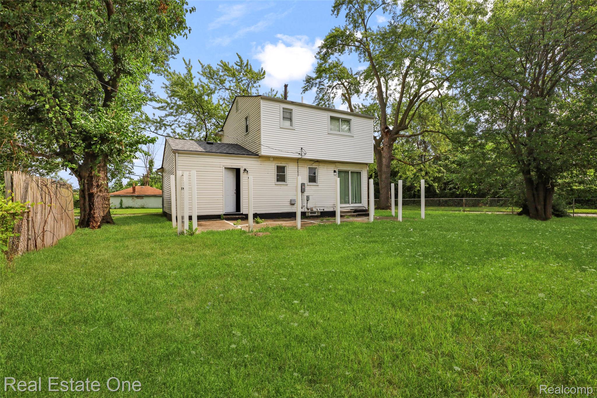 342 Melvin Street River Rouge, MI 48218 - Photo 7 of 30 Expansive grassy yard with mature trees and a wooden fence