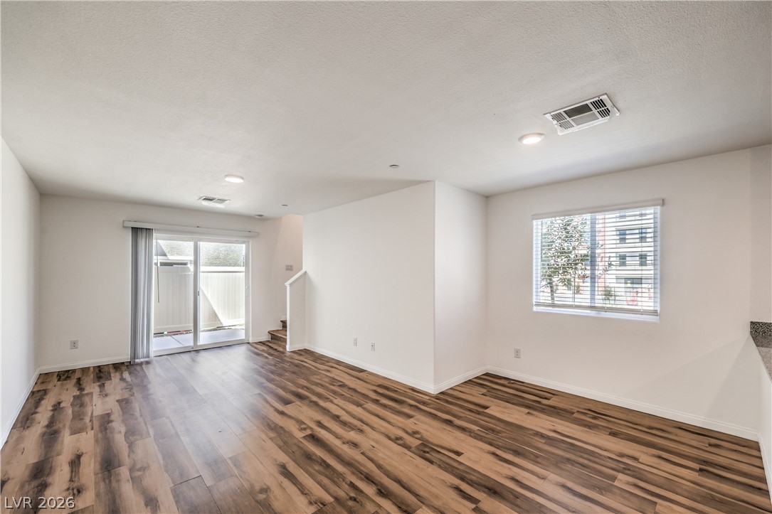 12103 Mojave Gold Road, Unit 4 Las Vegas, NV 89183 - Photo 4 of 23 Gleaming wood-look floors anchor a versatile living space equipped with sliding glass door access.