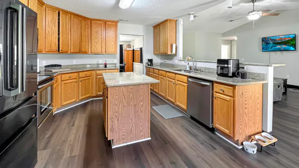 a kitchen with granite countertop wooden floors a stove and white appliances