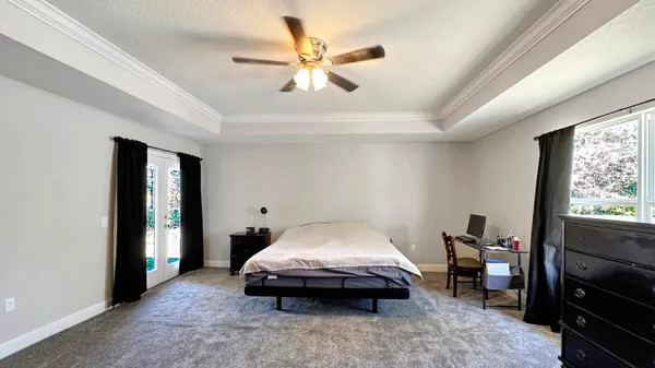 a bedroom with a bed and a flat tv screen on a dresser