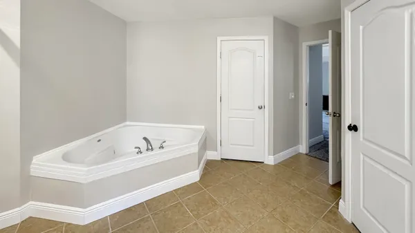 a spacious bathroom with a tub sink and mirror