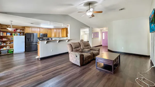 a living room with furniture and a kitchen view