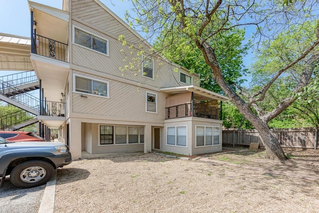 1010 West 23rd Street, Unit 15 Austin, TX 78705 - Photo 1 of 5 Back of property featuring a balcony, stairs, and fence