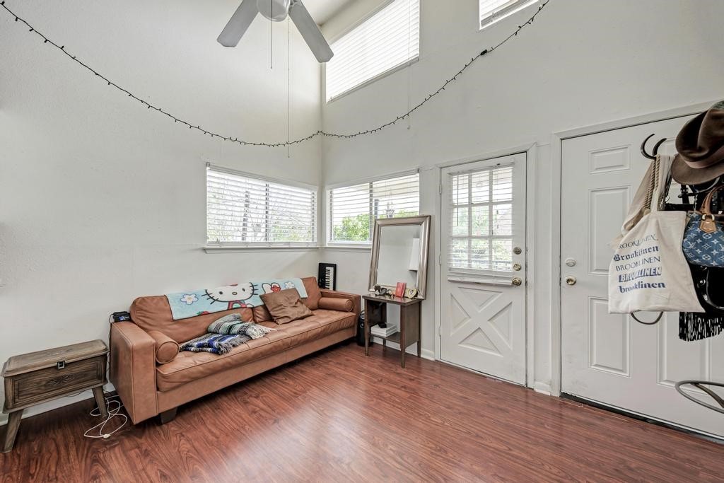 1010 West 23rd Street, Unit 15 Austin, TX 78705 - Photo 2 of 5 Living room with a ceiling fan, wood finished floors, and a towering ceiling