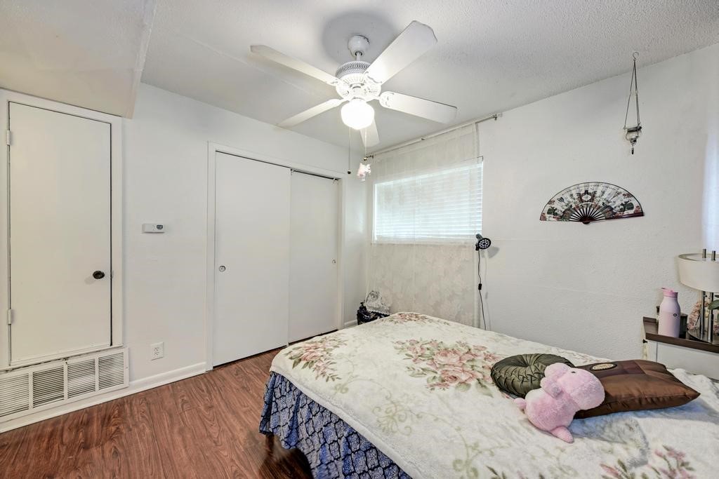 1010 West 23rd Street, Unit 15 Austin, TX 78705 - Photo 4 of 5 Bedroom featuring wood finished floors, a closet, and a ceiling fan