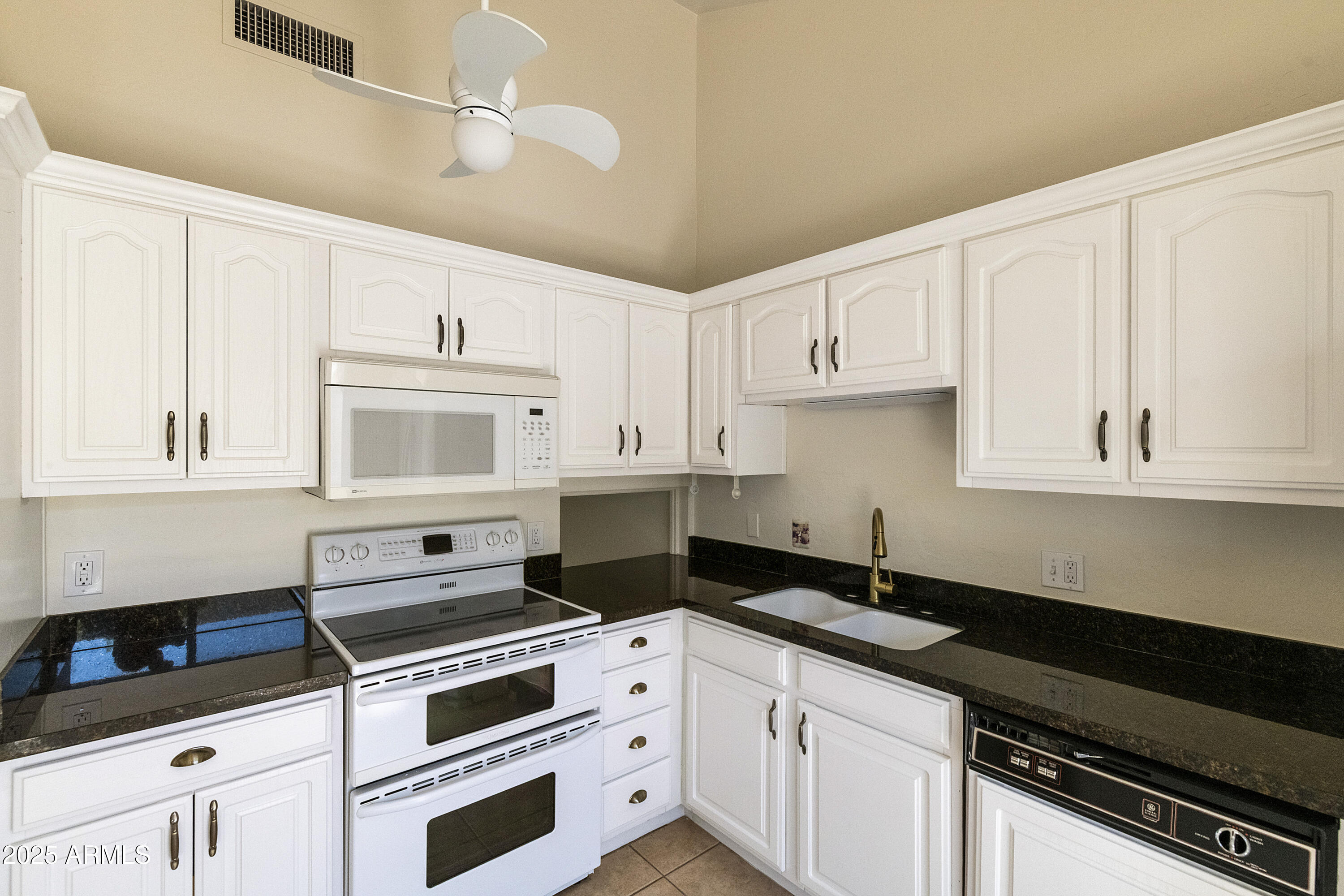 5622 North Palacio Way Phoenix, AZ 85014 - Photo 4 of 26 a kitchen with granite countertop white cabinets and black appliances