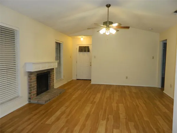 a view of a livingroom with a chandelier fireplace and wooden floor