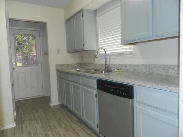 a kitchen with granite countertop cabinets stainless steel appliances and a wooden floor