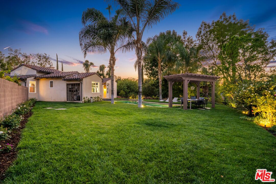 19261 Wells Drive Tarzana, CA 91356 - Photo 13 of 51 a view of a white house with a big yard and potted plants