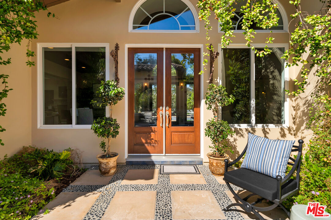 19261 Wells Drive Tarzana, CA 91356 - Photo 17 of 51 a view of a house with a chairs and table in a patio