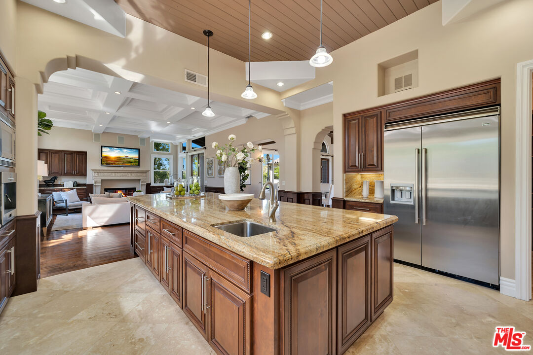 19261 Wells Drive Tarzana, CA 91356 - Photo 34 of 51 a kitchen with stainless steel appliances granite countertop a kitchen island a sink a stove and a refrigerator