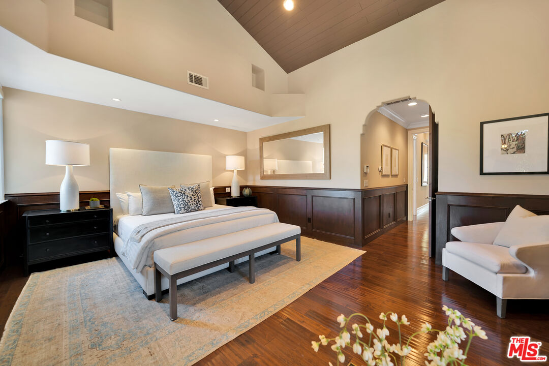 19261 Wells Drive Tarzana, CA 91356 - Photo 36 of 51 a spacious bedroom with a bed and wooden floor