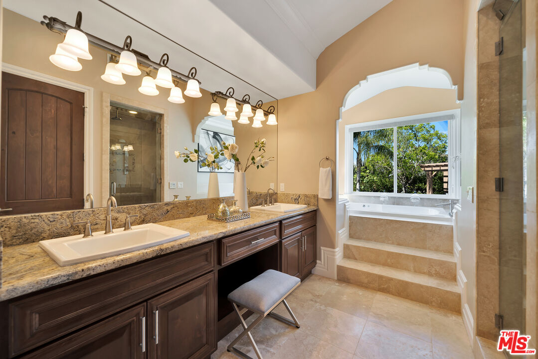 19261 Wells Drive Tarzana, CA 91356 - Photo 38 of 51 a bathroom with a granite countertop sink a toilet and a mirror