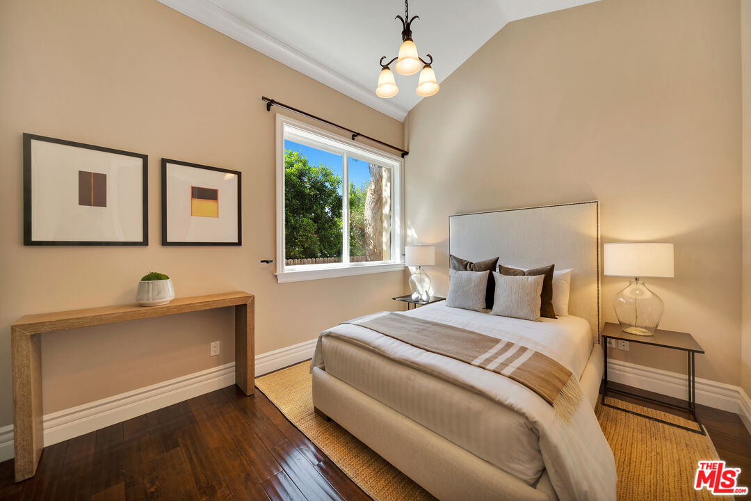 19261 Wells Drive Tarzana, CA 91356 - Photo 44 of 51 a bedroom with a large bed and a chandelier