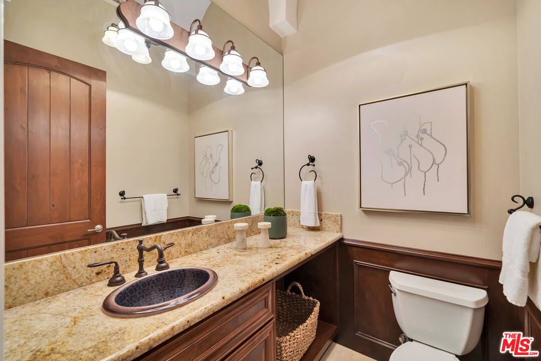 19261 Wells Drive Tarzana, CA 91356 - Photo 47 of 51 a bathroom with a granite countertop sink and a mirror