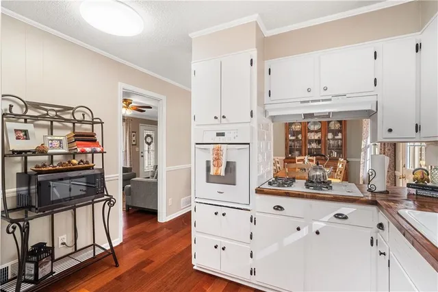 a kitchen with stainless steel appliances cabinets and a wooden floor
