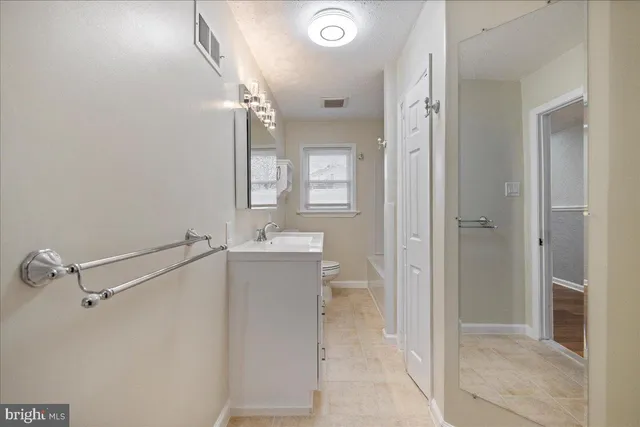 a bathroom with a granite countertop sink mirror and vanity