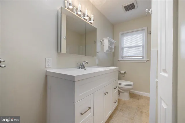 a bathroom with a toilet sink and mirror