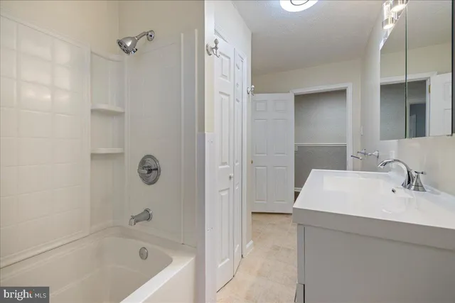 a bathroom with a bathtub sink vanity and mirror