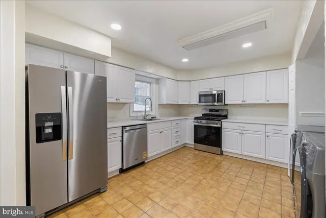 a kitchen with stainless steel appliances granite countertop a refrigerator sink and stove