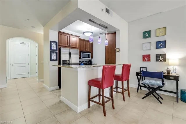 a room with stainless steel appliances kitchen island granite countertop furniture and a kitchen view