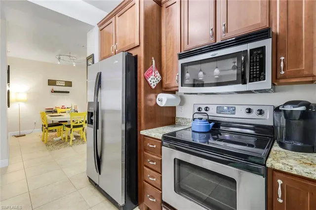 a kitchen with stainless steel appliances granite countertop a stove microwave and refrigerator