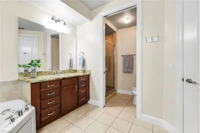 a spacious bathroom with a granite countertop sink and a mirror