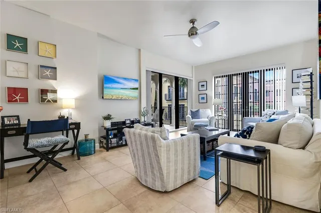a living room with furniture and floor to ceiling windows