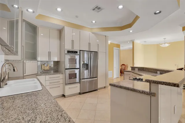 a large kitchen with stainless steel appliances kitchen island granite countertop a sink and cabinets
