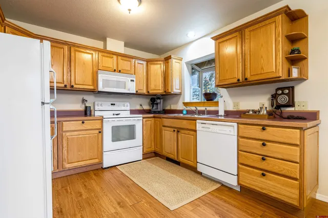 a kitchen with granite countertop a sink cabinets stainless steel appliances and a window