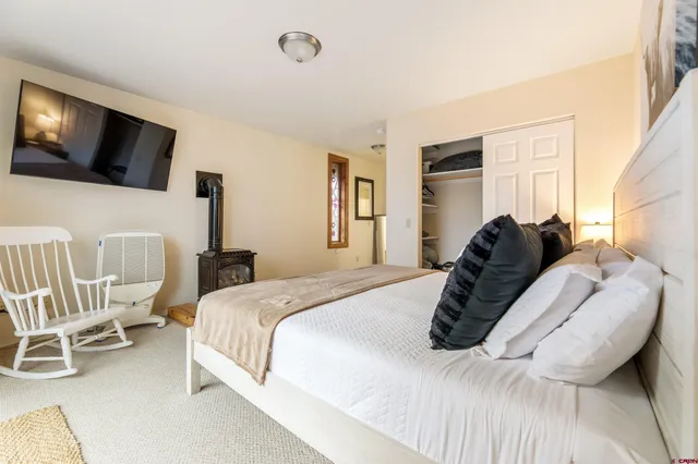 a bedroom with a bed tv and window