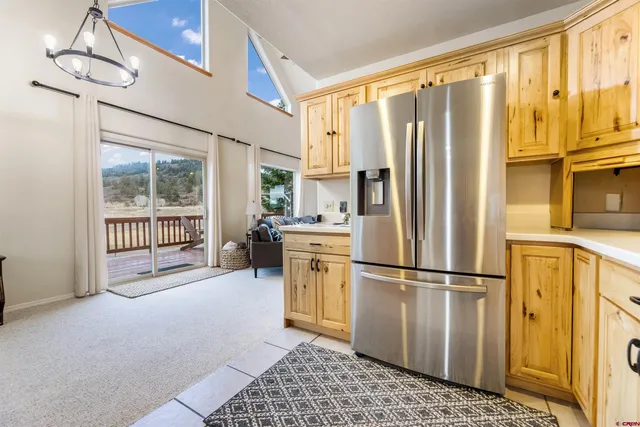 a kitchen with stainless steel appliances granite countertop a refrigerator a sink and a window