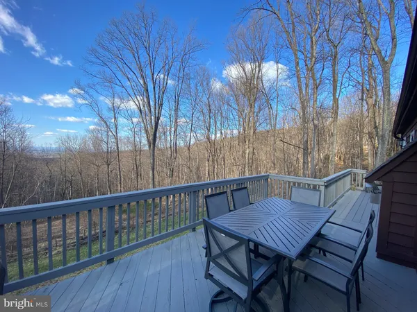 a view of backyard with deck and wooden fencing